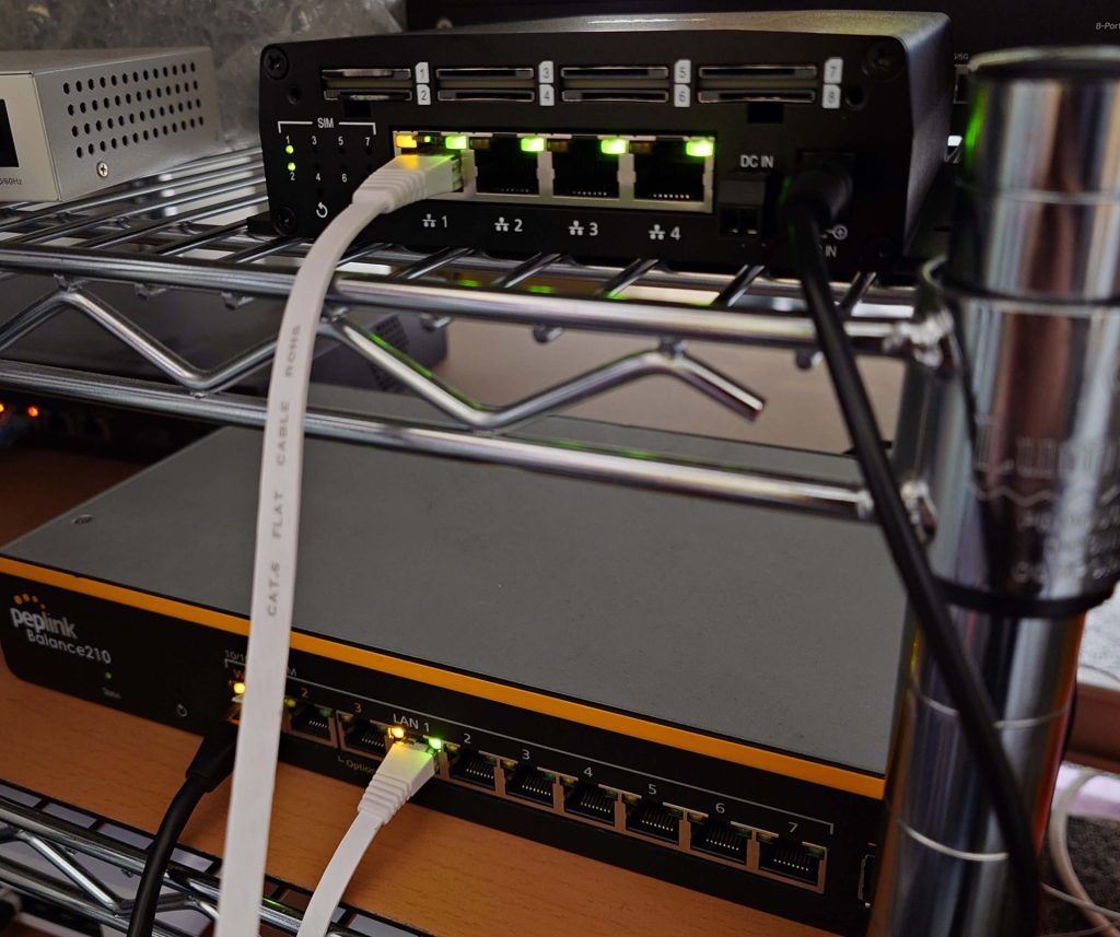 BalanceルーターとSIM InjectorをLANケーブルで接続した構成写真。白いLANケーブルが接続されている。